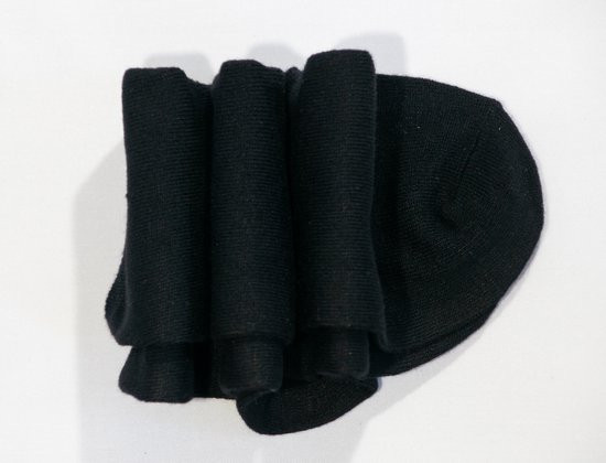 Drie opgerolde zwarte bamboe sokken.