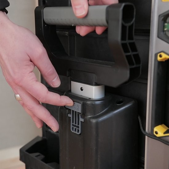 Grijze handgreep wordt op de zwarte gereedschapskoffer geplaatst met een duimbalkje.