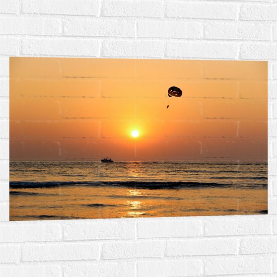 WallClassics - Muursticker - Parasailen bij Zonsondergang Boven de Zee - 90x60 cm Foto op Muursticker