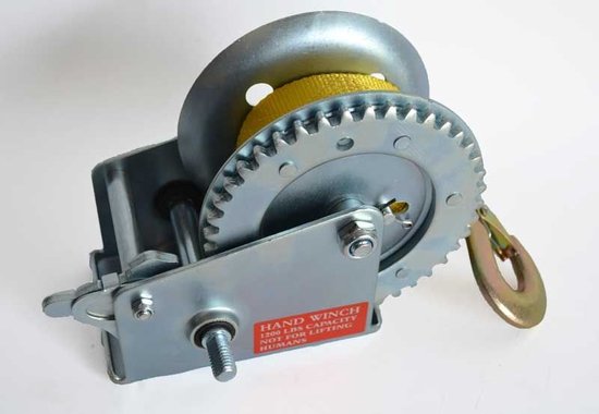 Verzinkte handlier met gele band. Rode sticker met 'HAND WINCH 1200 LBS CAPACITY NOT FOR LIFTING HUMANS'.