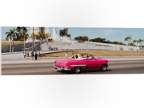 WallClassics - PVC Schuimplaat - Roze Cabrio in Stad - 90x30 cm Foto op PVC Schuimplaat (Met Ophangsysteem)