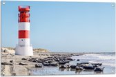 WallClassics - Tuinposter – Vuurtoren met Rotsen aan de Zee - 90x60 cm Foto op Tuinposter  (wanddecoratie voor buiten en binnen)