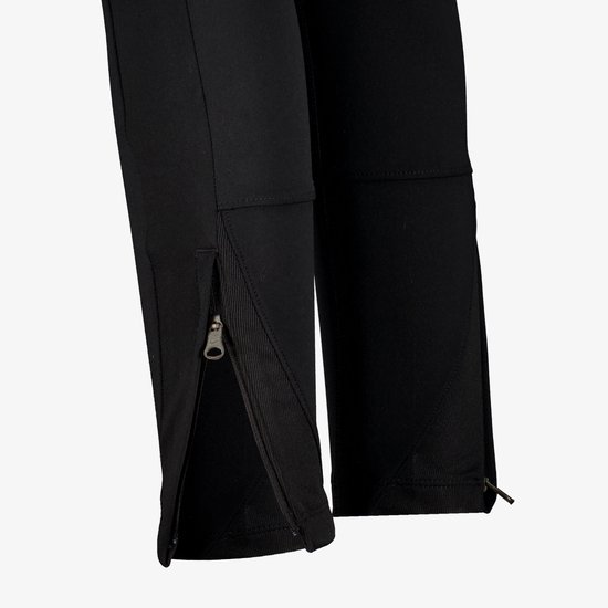 Sluiting van de rits aan de onderkant van een zwarte Nike trainingsbroek.