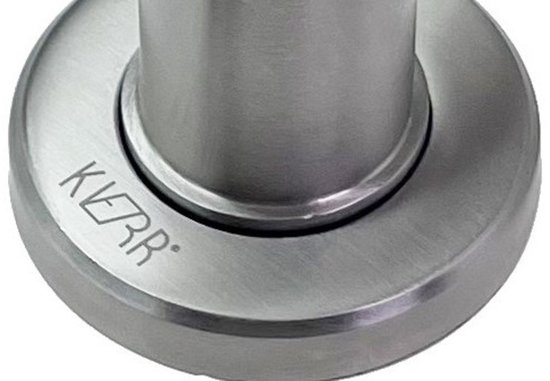 Close-up van de zilverkleurige, geborstelde metalen voet van een magnetische deurstopper met het KIER logo.