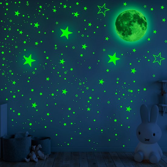 Autocollants muraux verts phosphorescents étoile et lune sur un mur de chambre d'enfant sombre.
