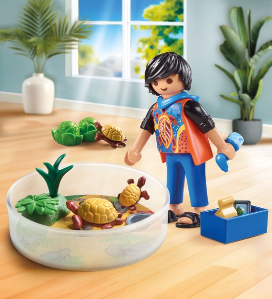 Playmobil jongen met schildpaddenterrarium in een lichte kamer. Jongen draagt een oranje vest over een zwart shirt.