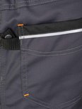 Pantalon de travail gris foncé avec coutures orange et une bande réfléchissante sur la poche arrière.