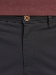 Zwarte chino broek met bruine knoop en kastanjebruin shirt.