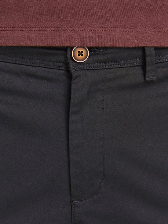 Zwarte chino broek met bruine knoop en kastanjebruin shirt.