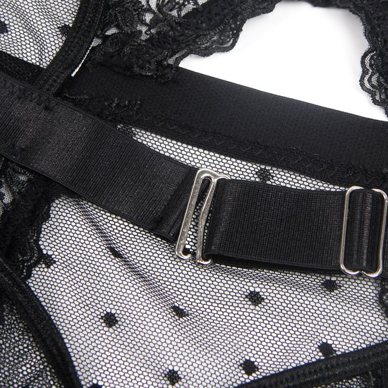 Close-up van de achterkant van een zwarte kanten bodysuit met stippen, met een verstelbare band en metalen gespen.