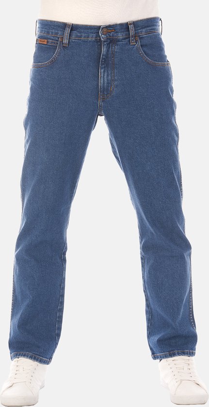 Blauwe Wrangler jeans, met bruin leren label op de voorkant en oranje stiksels.