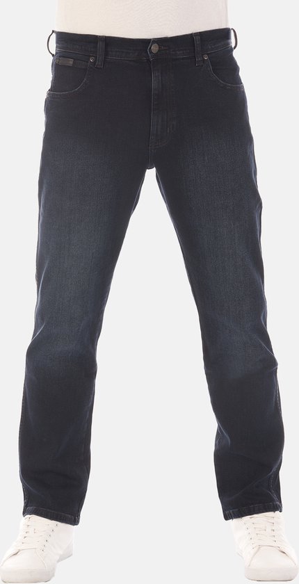 Man in een donkerblauwe straight fit jeans en witte sneakers.