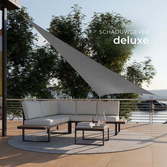 Grijze driehoekige zonnedoek "SCHADUWGEVER deluxe" boven een hoekbank op een terras.