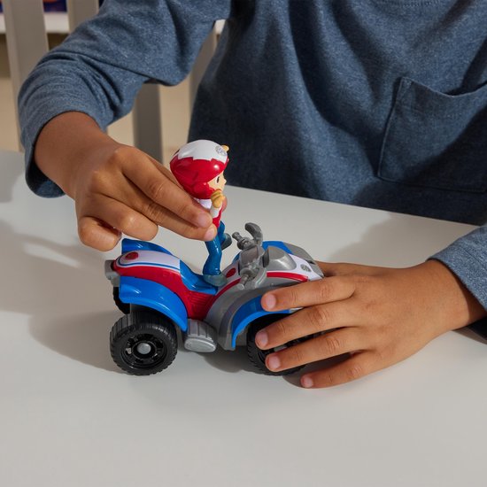 Een kind plaatst Ryder op zijn rode, witte en blauwe ATV.