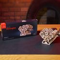 Houten V8 motor model op de doos met de tekst "V8 Engine" in een donkere omgeving.