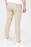 Achterkant van een mannen chino in lichtbeige, gedragen met witte sneakers.