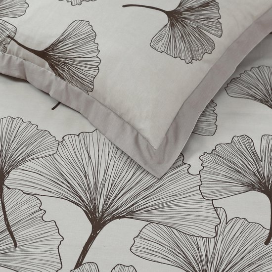 Close-up van een beige kussensloop met bruine ginkgo bladeren en een beige rand.