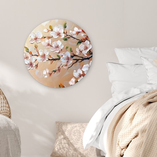 Wandcirkel met schilderachtige roze bloesemtakken, hangend aan een muur boven een bed.