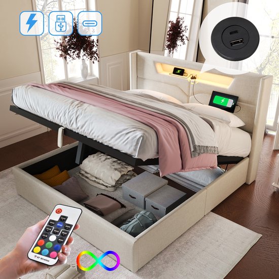 Lit rembourré beige avec espace de rangement relevable, éclairage LED et ports USB. La télécommande pour l'éclairage est visible.