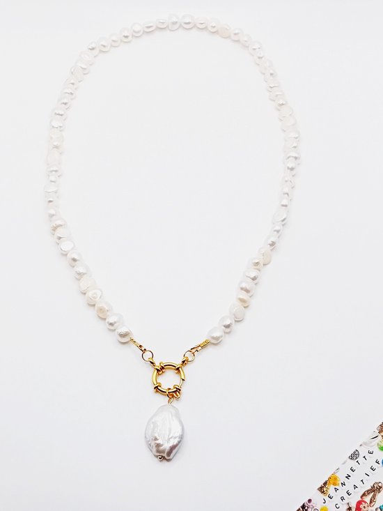 Ketting van zoetwaterparels met gouden sluiting en barokke parel bedel, op witte achtergrond.