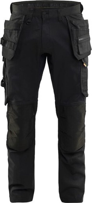 Zwarte werkbroek met vele zakken, gedetailleerd met zwarte kniepatches.