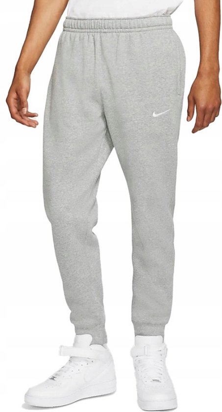 Man met grijze Nike joggingbroek met kleine witte Nike swoosh.
