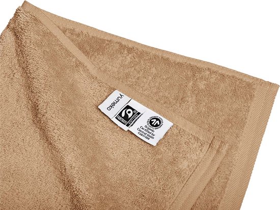 Serviette beige Yumeko avec étiquettes, y compris la certification Fairtrade et coton biologique.