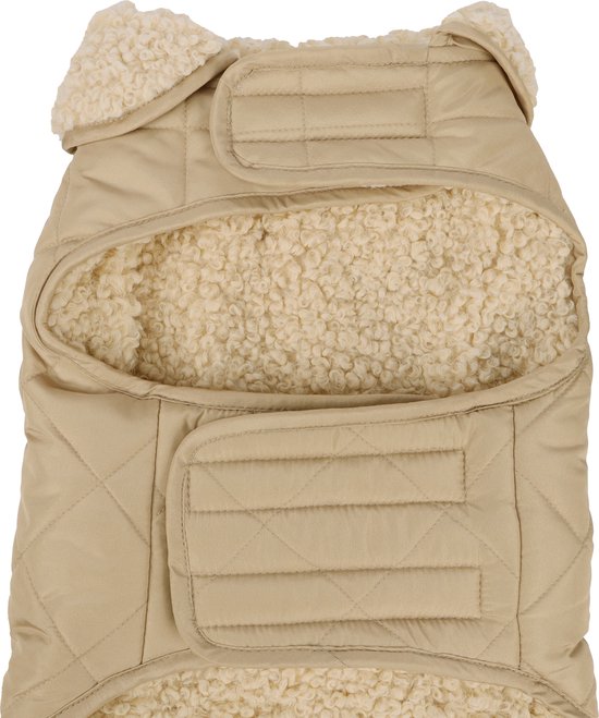 Onderkant van een beige, gewatteerde hondenjas, met klittenbandsluitingen en beige teddy voering.