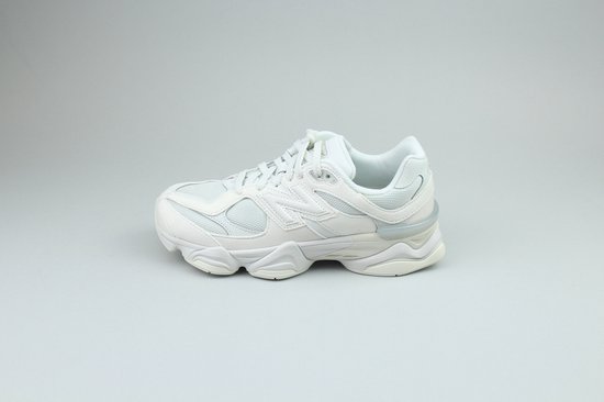 Witte New Balance 9060 sneaker met mesh en leren overlays, op een dikke witte zool, met het New Balance logo op de zijkant.