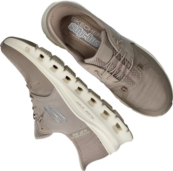 Een paar beige Skechers Slip-ins met een mesh bovenwerk, witte zool met GLIDE-STEP opdruk en zilverkleurige Skechers logo's.
