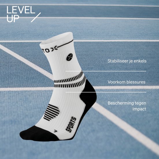 Witte sportsokken met zwarte accenten en "SPORTS" logo. Gerichte compressie voor enkelstabiliteit.