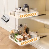 Uittrekbare keukenlades met oranje pijltjes. Bovenste lade met pannen en mokken. Onderste lade met keukengerei, eieren en schalen.