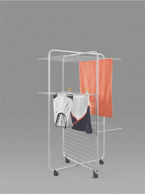 Witte droogtoren met drie verdiepingen, met een oranje handdoek en kledingstukken erop.