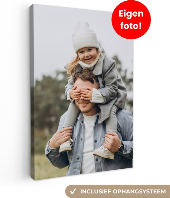 Un père porte sa fille sur ses épaules. Elle lui couvre les yeux avec ses mains. Ils portent des vêtements d'hiver.