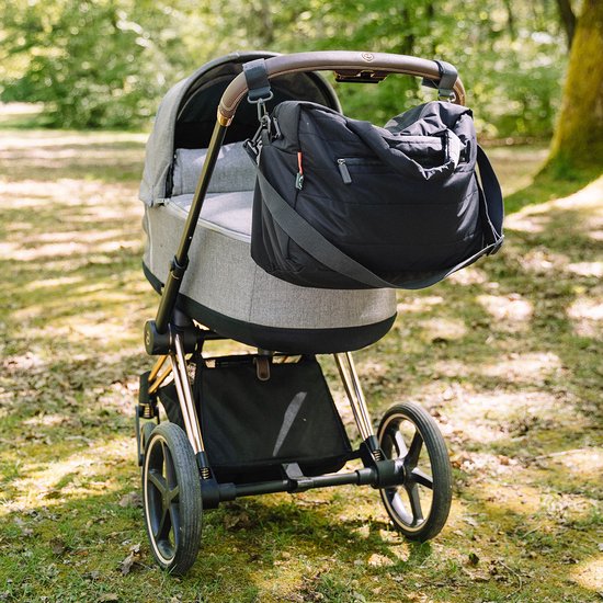 Sac à langer noir suspendu à une poussette.