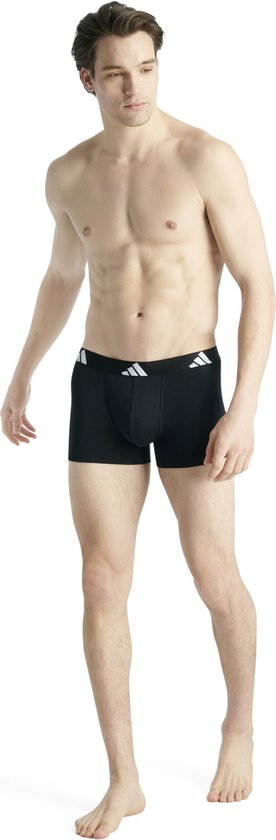 Man in zwarte boxer met zwarte band en Adidas logo.