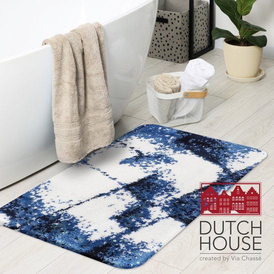 Een badkamer met een badmat met een abstract blauw en wit patroon, naast een ligbad.