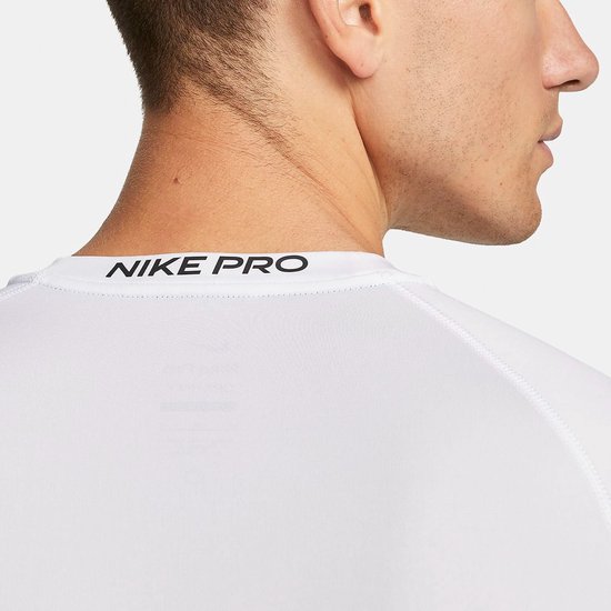 Close-up van de achterkant van een wit Nike Pro longsleeve shirt met zwarte Nike Pro tekst op de kraag.
