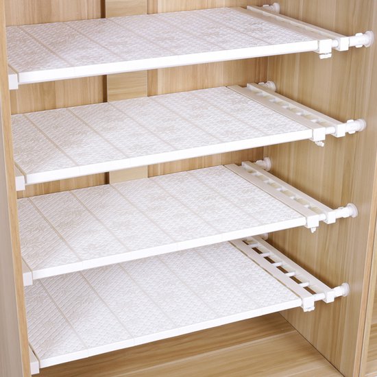 Étagère blanche extensible avec un motif de petits points, installée dans une armoire en bois.