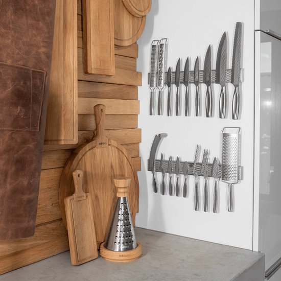 Set van keukenmessen op een magneetstrip naast houten keukengerei.