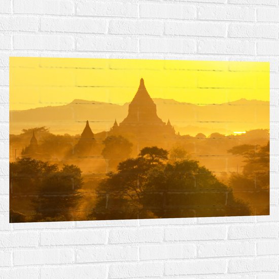 Muursticker - Schermige Zon achter Tempels - 105x70 cm Foto op Muursticker