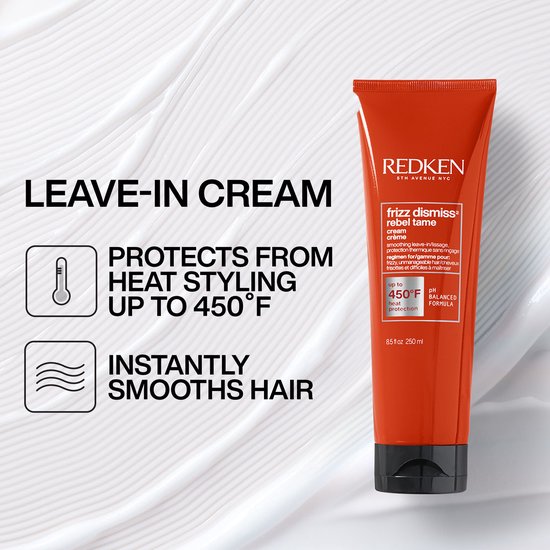 Een rode tube met tekst 'REDKEN frizz dismiss rebel tame' en informatie over hittebescherming tot 450°F.