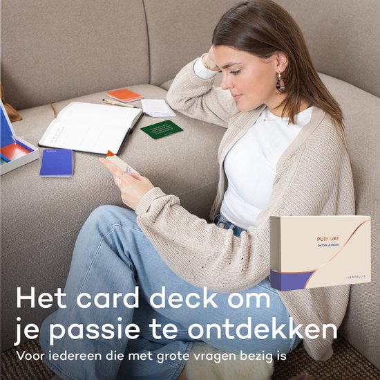 Een vrouw zit op een bank en leest een kaart. Een notitieboek en een open doos met kaarten liggen naast haar.