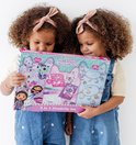 Twee meisjes met krullend haar houden een Gabby's Poppenhuis knutselpakket vast.