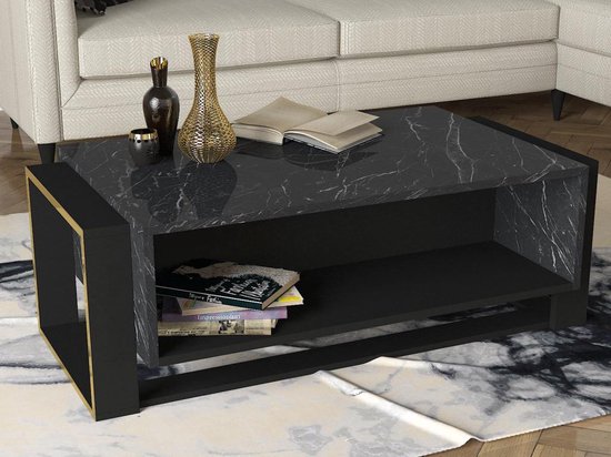 Salontafel met zwart gemarmerd blad, zwart onderstel en gouden accenten. Een open vak met boeken.