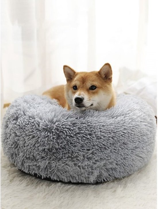 Shiba Inu hond in een ronde, zachte, grijze mand.