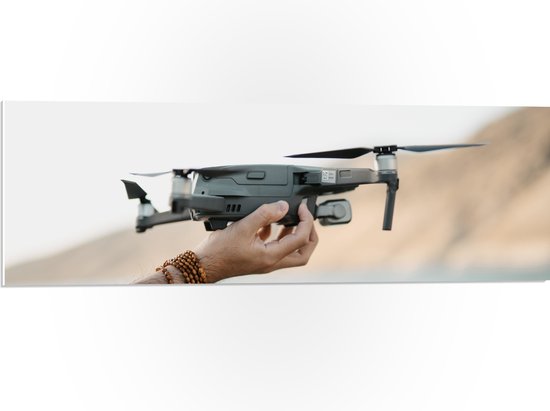 PVC Schuimplaat - Drone in Handen van Mensen - 90x30 cm Foto op PVC Schuimplaat (Met Ophangsysteem)