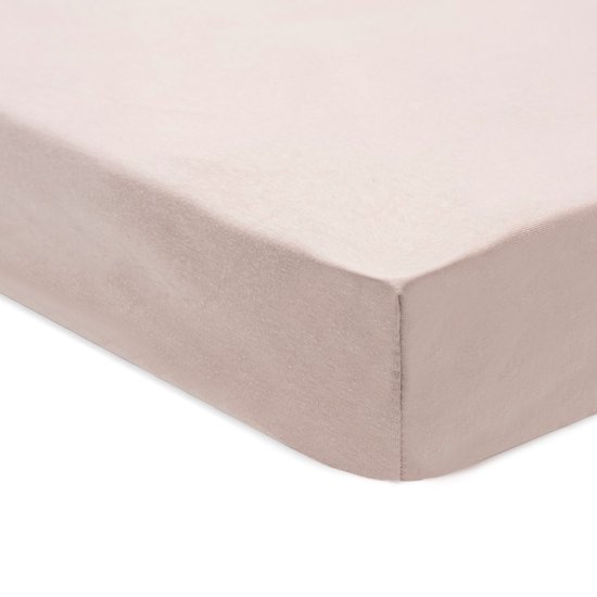 Roze jersey hoeslaken voor een babybed.