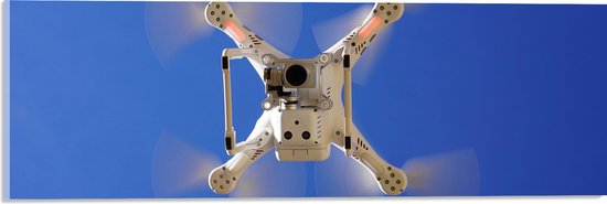 Acrylglas - Onderaanzicht van Vliegende Drone onder Blauwe Lucht - 60x20 cm Foto op Acrylglas (Met Ophangsysteem)