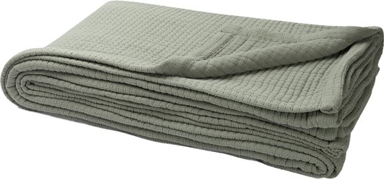 Opgevouwen sagegroene mousseline deken met wafelpatroon.